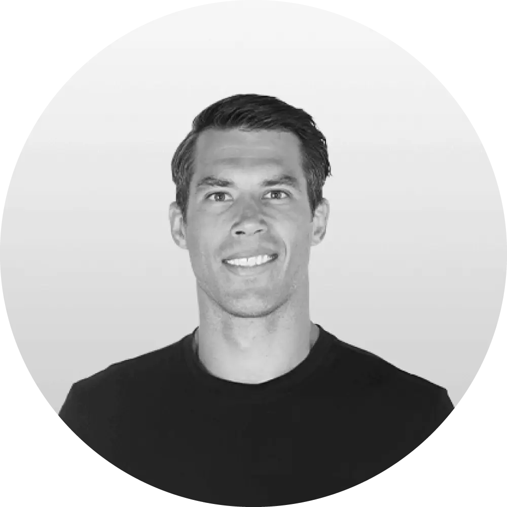 Smiling man in a black shirt against a light gray circular background